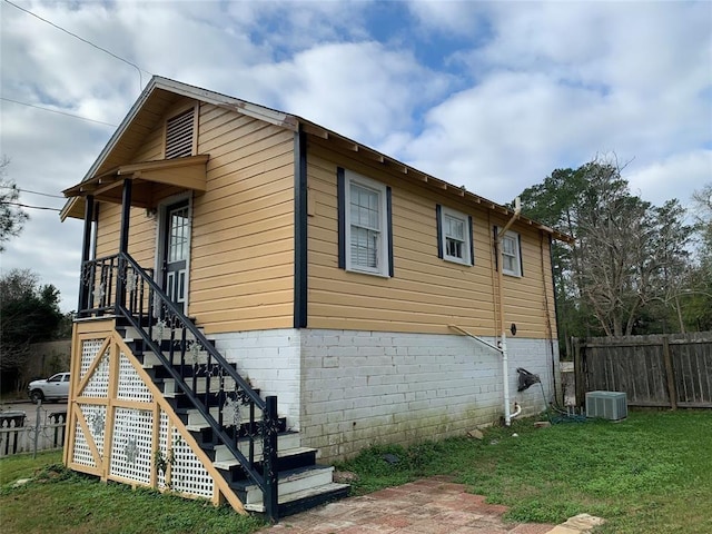 view of property exterior with a yard and cooling unit