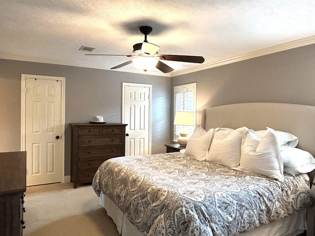 bedroom featuring light carpet, a textured ceiling, ceiling fan, and ornamental molding