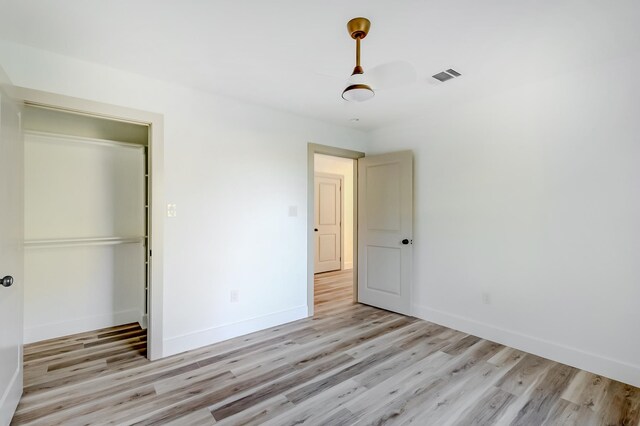 unfurnished bedroom featuring a closet and light wood-type flooring