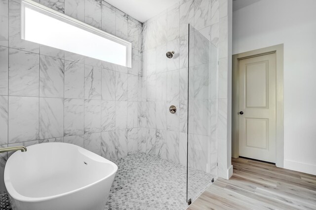 bathroom with plus walk in shower and hardwood / wood-style flooring