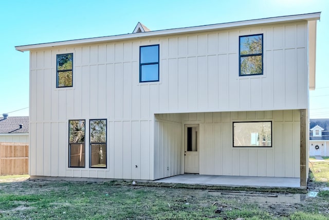 rear view of property featuring a patio and a lawn