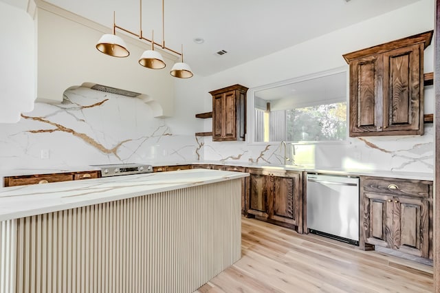 kitchen featuring stainless steel dishwasher, decorative light fixtures, light hardwood / wood-style floors, and backsplash