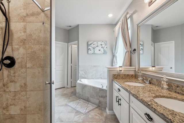 bathroom featuring tile patterned floors, vanity, and shower with separate bathtub