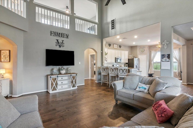 living room with dark hardwood / wood-style flooring and a high ceiling