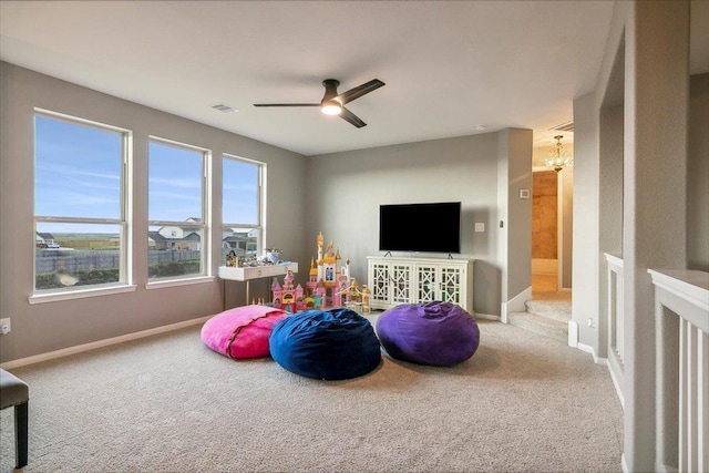 rec room featuring carpet and ceiling fan with notable chandelier