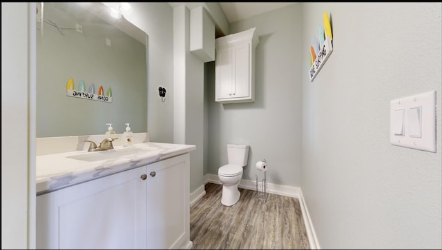 335 Atkinson, Crystal Beach, TX 77650 - bathroom with wood finished floors, toilet, vanity, and baseboards