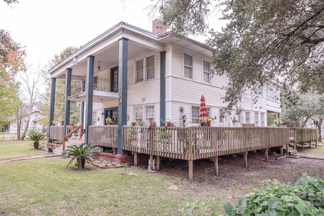 2350 Pecos Blvd, Beaumont, TX 77702 - rear view of house featuring a balcony, a yard, a chimney, and a wooden deck
