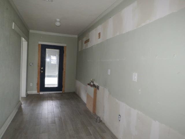 doorway featuring crown molding and dark hardwood / wood-style flooring