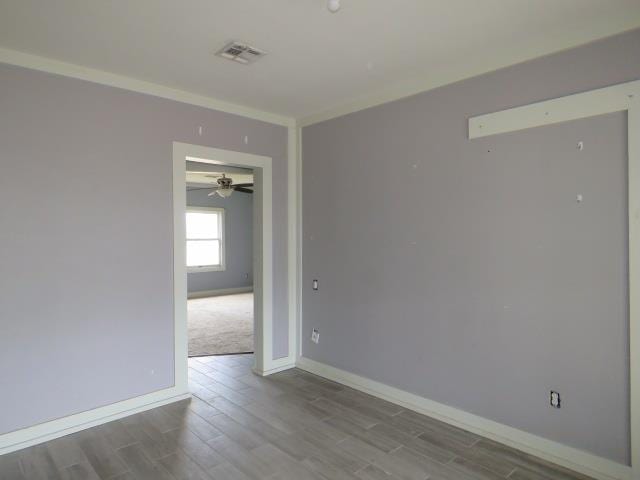 unfurnished room with hardwood / wood-style floors and ornamental molding