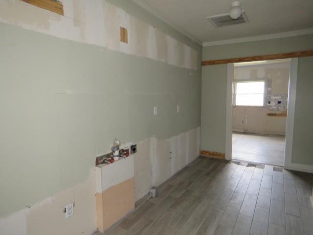 empty room featuring hardwood / wood-style flooring and ornamental molding