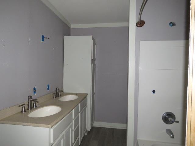 bathroom with vanity, wood-type flooring, ornamental molding, and shower / bath combination