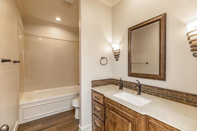 full bathroom with toilet, tasteful backsplash, wood-type flooring, ornamental molding, and vanity