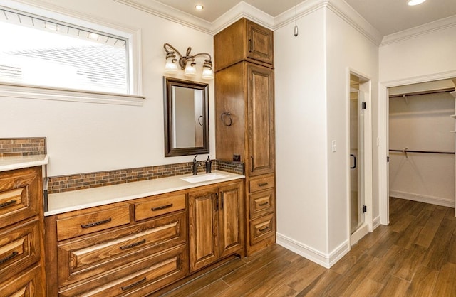 bathroom with tasteful backsplash, vanity, hardwood / wood-style flooring, and ornamental molding