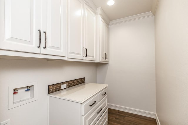 washroom featuring hookup for a washing machine, dark hardwood / wood-style floors, ornamental molding, and cabinets