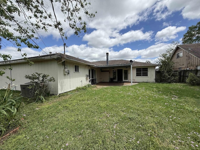 rear view of property with a yard, a patio, and fence
