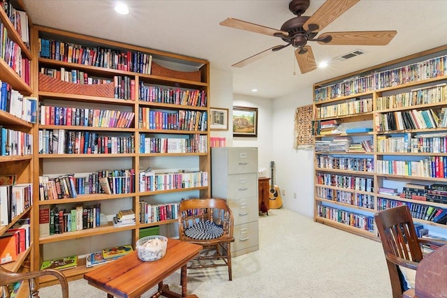 sitting room with ceiling fan and light carpet