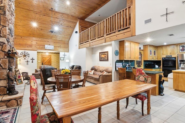 tiled dining room featuring a towering ceiling and wooden ceiling