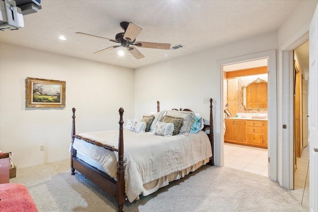 tiled bedroom with a textured ceiling, connected bathroom, and ceiling fan