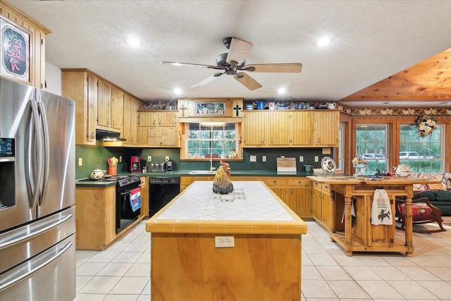 kitchen featuring black appliances, a kitchen island, sink, and a wealth of natural light