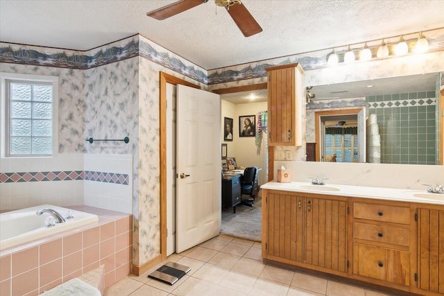 bathroom featuring tiled bath, tile patterned flooring, vanity, and a textured ceiling