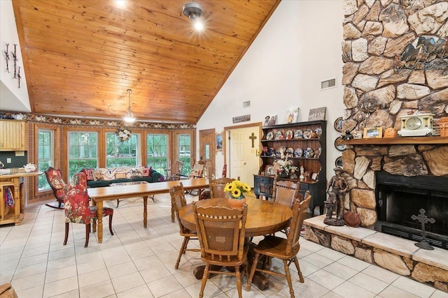 dining space featuring a fireplace, light tile patterned flooring, high vaulted ceiling, and wood ceiling