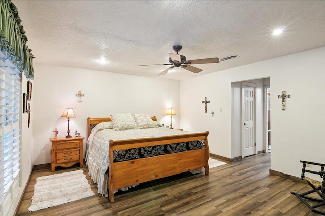 bedroom featuring a textured ceiling, ceiling fan, and dark hardwood / wood-style floors