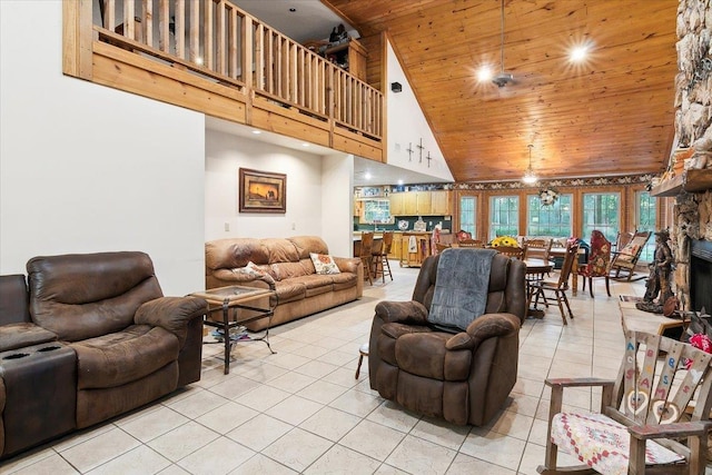 living room with wooden ceiling, high vaulted ceiling, ceiling fan, light tile patterned floors, and a fireplace