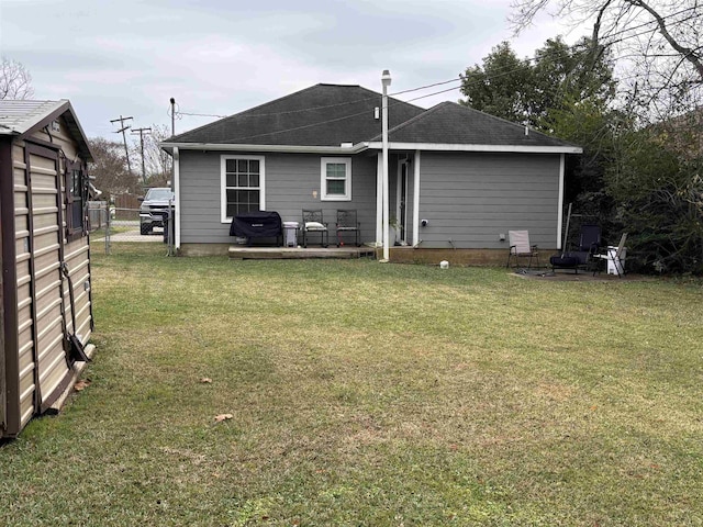 rear view of property with a patio area, a yard, and an outdoor fire pit