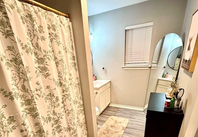 bathroom with vanity, hardwood / wood-style flooring, toilet, and curtained shower