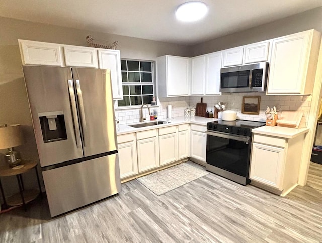 kitchen featuring white cabinets, decorative backsplash, sink, and stainless steel appliances