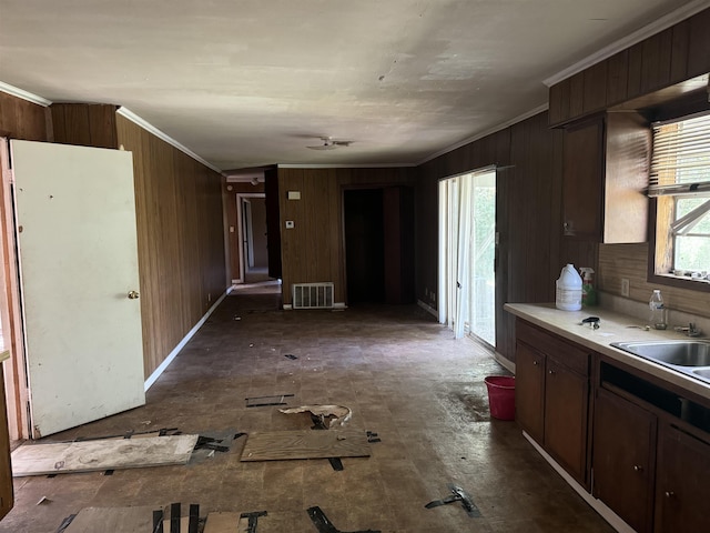 kitchen featuring crown molding, light countertops, visible vents, and a sink