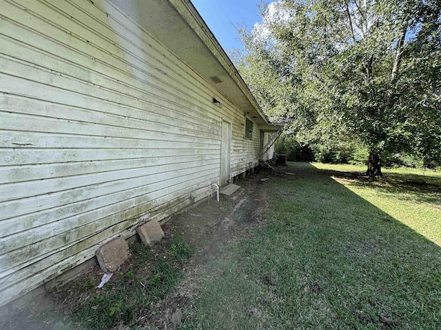 view of side of home with a yard