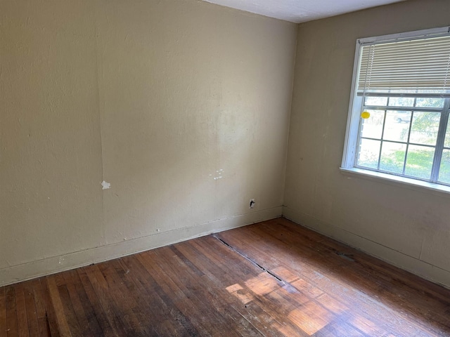 empty room featuring hardwood / wood-style flooring and baseboards