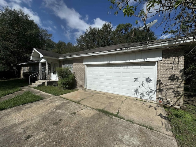 view of front facade featuring an attached garage, driveway, and brick siding