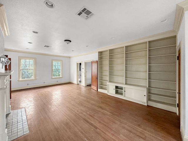 unfurnished living room with visible vents, crown molding, baseboards, and wood finished floors