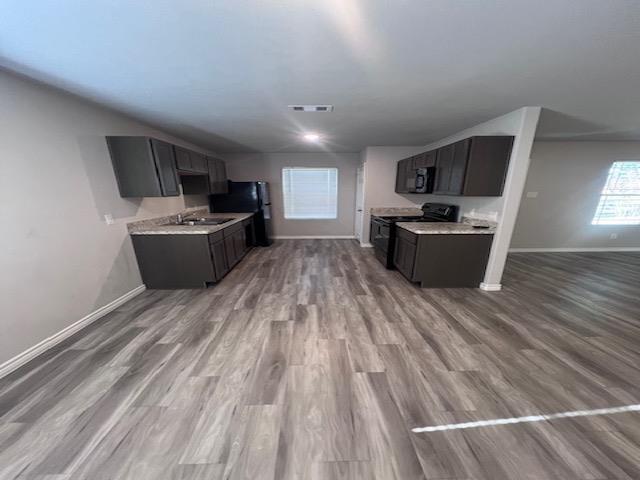 kitchen featuring black appliances, light hardwood / wood-style floors, and sink