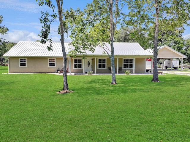 view of front of home with a carport, metal roof, driveway, and a front lawn