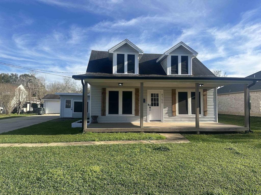 back of property featuring covered porch and a lawn