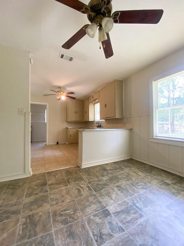 kitchen featuring kitchen peninsula, ceiling fan, and sink