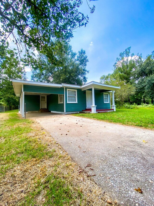 ranch-style home with a front lawn and a carport