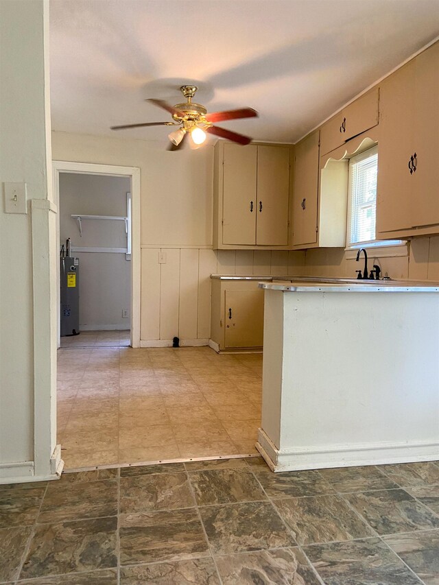 kitchen with cream cabinetry, electric water heater, ceiling fan, and sink