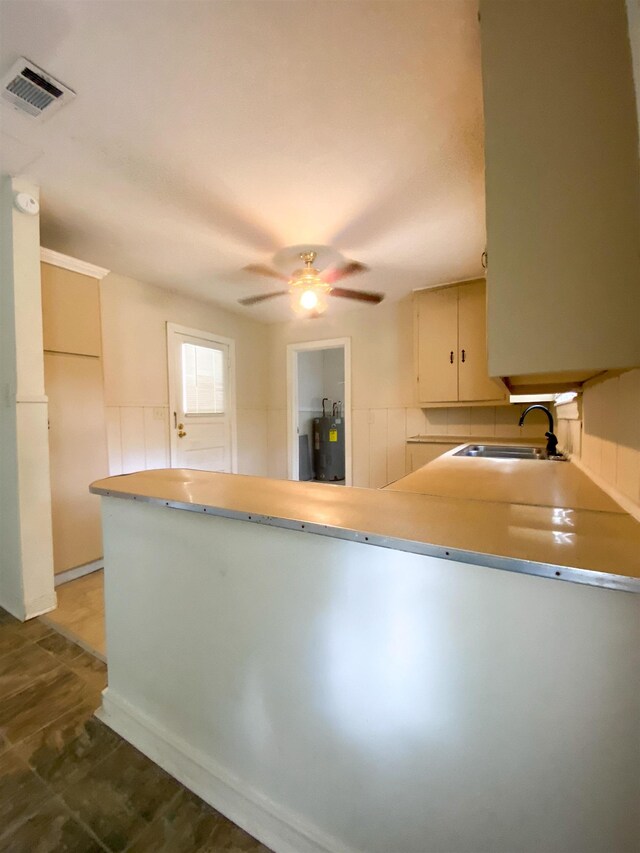kitchen with kitchen peninsula, ceiling fan, and sink