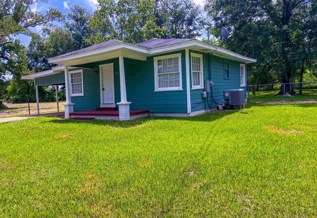 view of front facade featuring a porch, central AC unit, and a front yard
