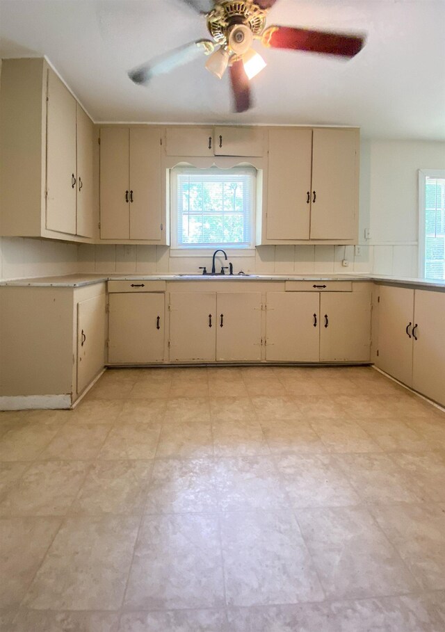 kitchen with ceiling fan, cream cabinets, and sink