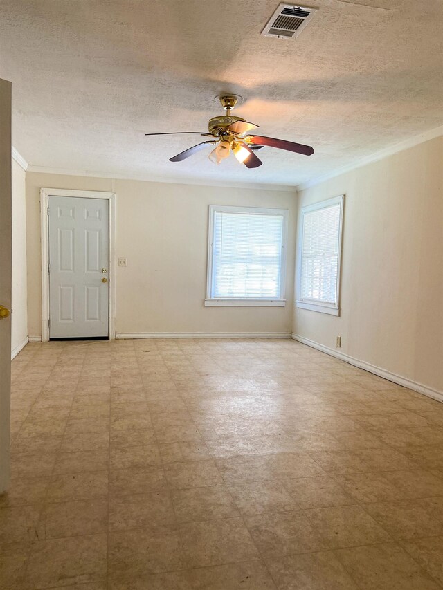 empty room featuring ceiling fan, a textured ceiling, and ornamental molding