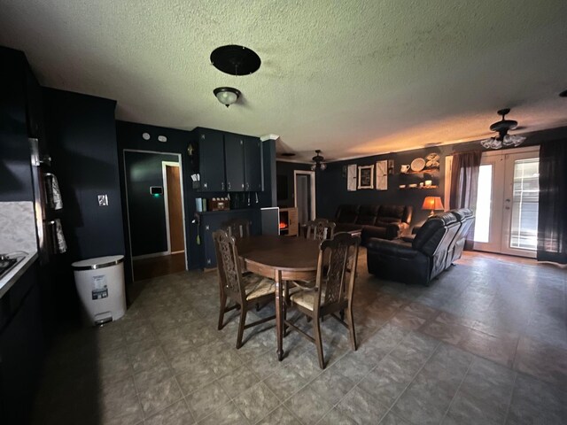 dining room with ceiling fan, a textured ceiling, and french doors