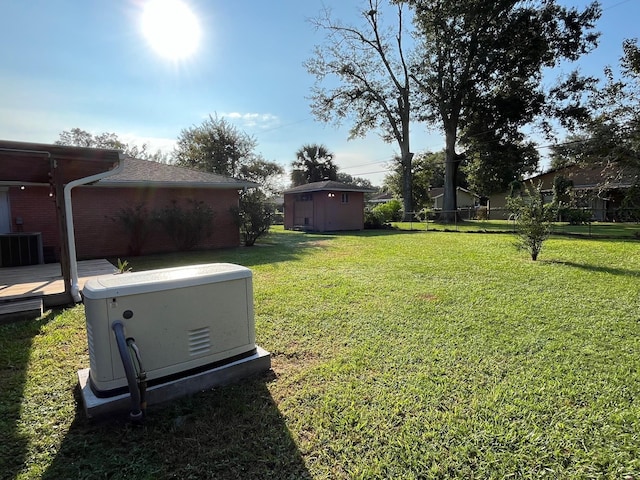 view of yard with a shed, a wooden deck, and central AC