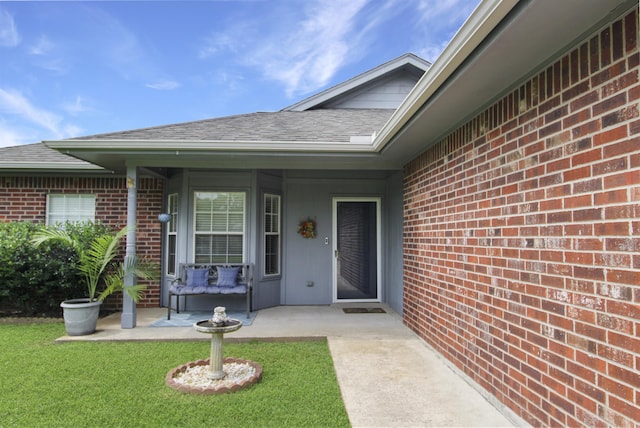 465 Lytton Dr, Vidor, TX 77662 - entrance to property with brick siding, a patio area, a shingled roof, and a lawn