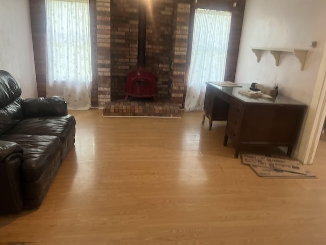 living room with a wood stove, plenty of natural light, and light hardwood / wood-style floors