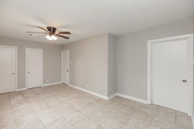 unfurnished bedroom featuring visible vents, baseboards, ceiling fan, and multiple closets